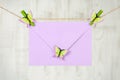 Light purple envelope from recycled paper hanging on a jute twine with green clothes pins with decorative butterflies. Hello Royalty Free Stock Photo