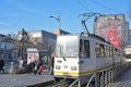 A tram of Bucharest light rail along Bulevardul Ion C. Bratianu with large billboard & street clock in Bucharest, Romania