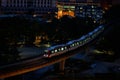 Light rail transit train moving through the city in the night Royalty Free Stock Photo