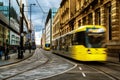 Light rail yellow tram in the city center of Manchester, UK