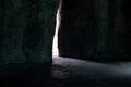Light ray between stones in cave. Hidden exit