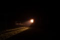 Light rays from the window of a rural house at night in the fog Royalty Free Stock Photo