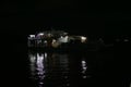 The light reflection of a goods ferry on the Amazon river during night time , at the busy port of Manaus, Brazil