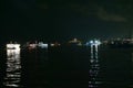 The light reflection of several goods ferries on the Amazon river, with the red lit bridge in the background during night time, at Royalty Free Stock Photo