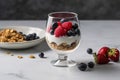 A light, refreshing breakfast of Greek yogurt, topped with a variety of fresh berries, honey, and granola, served in a glass