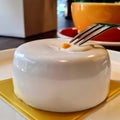 A light round cake stands on a plate in