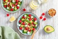 Light salad with raspberry, baby spinach, feta cheese, avocado and walnuts, top view. Fresh original summer salad with