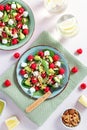 Light salad with raspberry, baby spinach, feta cheese, avocado and walnuts, top view. Fresh original summer salad with lemon water Royalty Free Stock Photo