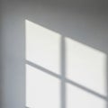 Light and shadow create a geometric pattern on a smooth, pale gray wall. The shadow Royalty Free Stock Photo
