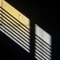 Light and shadow interplay create diagonal lines across a textured concrete wall Royalty Free Stock Photo