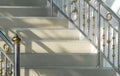 Light and shadow on surface of beige tile steps with stainless steel railing of vintage staircase Royalty Free Stock Photo