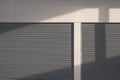 Light and shadow on surface of the old 2 steel roller Shutter Doors with gypsum board wall of Warehouse building