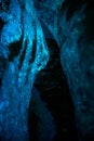 Light shining into a dark ice cave illuminating the cracked ice of the walls Royalty Free Stock Photo