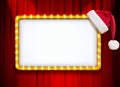 Light sign with gold frame and Christmas hat on red theatre or cinema curtain Royalty Free Stock Photo