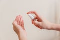 Light-skinned Asian woman pumping a hand sanitizer spray bottle to another hand. Royalty Free Stock Photo