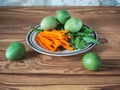 Light snack of chopped carrots and fresh sorrel and chicken eggs painted in green on a round striped plate on a wooden background Royalty Free Stock Photo