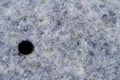 Light snow cover on a blue metal surface with a round hole, snowy background Royalty Free Stock Photo