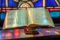 Light from stained glass window falls on open bible in american church Royalty Free Stock Photo