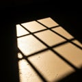 Light streaming through a window creates a grid-like shadow pattern on a textured Royalty Free Stock Photo