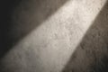 Light streams through cracks in a dark room, creating dramatic shadows on the textured wall surface Royalty Free Stock Photo