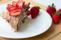 Light summer dessert: a slice of crepe layer cake with whipped cream, chocolate chips and strawberries between the layers. Royalty Free Stock Photo