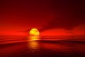 Light sunset orange sun calm orange sea with sun through nature horizon over the water with a cloudy sky Royalty Free Stock Photo