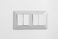 Light switch with four buttons on white wall at home. One button switch on. Power, electricity, environmental conservation, energy Royalty Free Stock Photo