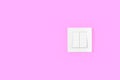 Light switch on pink wall. Electricity and light symbol