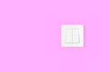 Light switch on pink wall. Electricity and light symbol Royalty Free Stock Photo