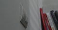 Light switch on a white wall, blurred books in the background. Royalty Free Stock Photo