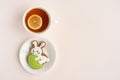 On a light table, a gingerbread in the shape of a rabbit with an Easter egg and a cup of tea with lemon Royalty Free Stock Photo