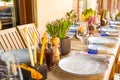 Light Table set for wedding or another catered event dinner. Wooden table served with plates, forks, spoons, glasses, napkins in t Royalty Free Stock Photo