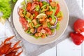 Light tasty salad with meat of a cancer, shrimps, lettuce, garlic croutons, tomatoes, red onions