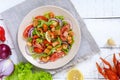 Light tasty salad with meat of a cancer, shrimps, lettuce, garlic croutons, tomatoes, red onions on a white background. Royalty Free Stock Photo