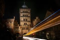 Light traces of a bus driving through the Burgtor gate tower of Lubeck at night, historic brick building of the former city