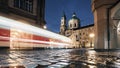 Light trail of tram passing between historical buildings at night Royalty Free Stock Photo