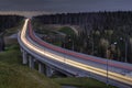 Light trails on four lane highway, crosses the night forest. Royalty Free Stock Photo