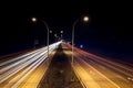 Speed traffic - light trails on highway at night. Cars exiting highway Royalty Free Stock Photo