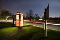 Light trails on a rural road, with phone box Royalty Free Stock Photo