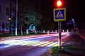 light trails on the street and a singn of crossing a road with a traffic lights