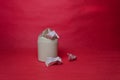 Light trash bin on red background. Closeup of crumpled sheets of paper. Concept of environmental recycling paper waste