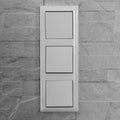 Light triple white electricity switch. Switch on a brick Royalty Free Stock Photo