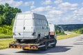 Light truck - tow truck, transports a white, damaged, broken minibus to itself along the highway between cities