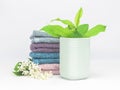 Light turquoise ceramic tumbler with soft towels, fresh flowers and leaves. Bathroom wellness spa concept Royalty Free Stock Photo