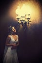 Light of vintage chandelier illuminates a pretty bride