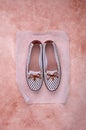 Light women`s shoes with a bow and perforation on a brown background Royalty Free Stock Photo