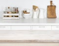 Light wood table with bokeh image of kitchen counter interior