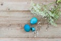 Light wooden background and bright blue Easter eggs with white spring flowers. Space for text. Flat lay Royalty Free Stock Photo