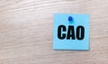 On a light wooden background - a light blue square sticker with the text CAO Chief Accounting Officer Royalty Free Stock Photo