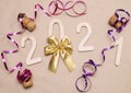 Light wooden 2021 numbers lie randomly on craft paper with champagne corks, packing tape, muzlet and gold bow Royalty Free Stock Photo